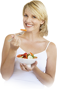A smiling woman eating vegetables