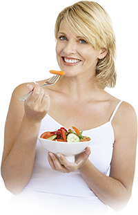 A smiling woman eating vegetables